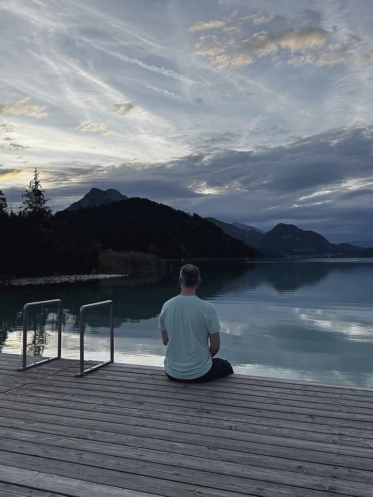 Alexandr Scerbina, văzut din spate, pe un ponton la lac, seara