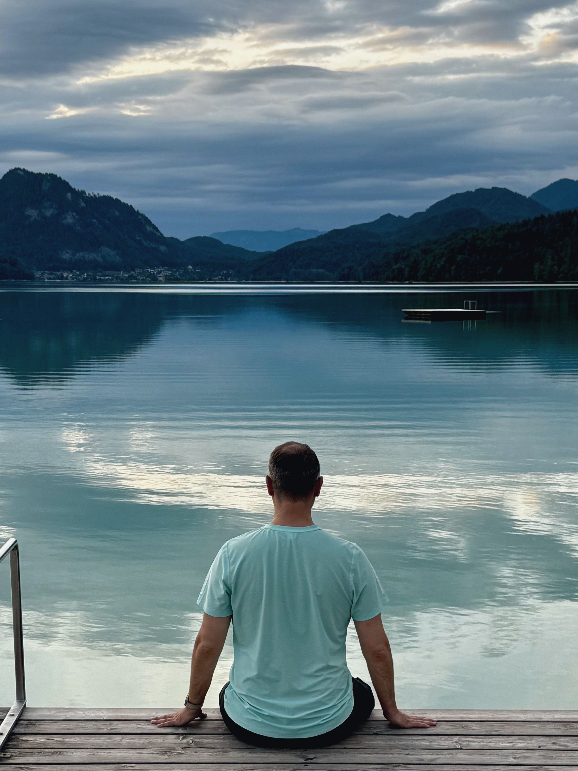 Alexandr Scerbina, văzut din spate, pe un ponton la un lac de munte